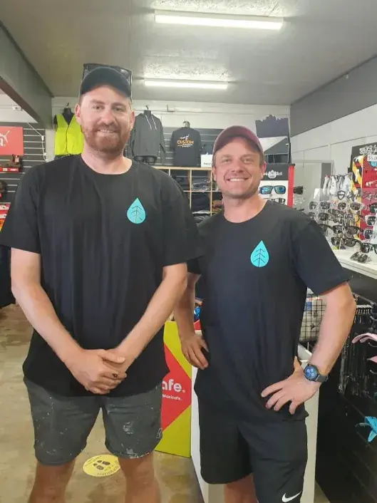Two customers in branded black t-shirts inside the Custom Workwear store