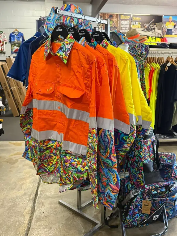 Hi-vis orange work shirts and patterned shirts on a rack at Custom Workwear